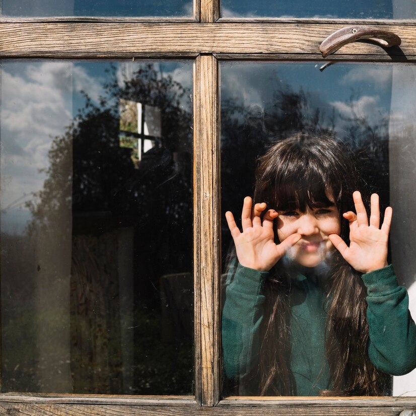 cute-girl-looking-through-glass-window_23-2147824116